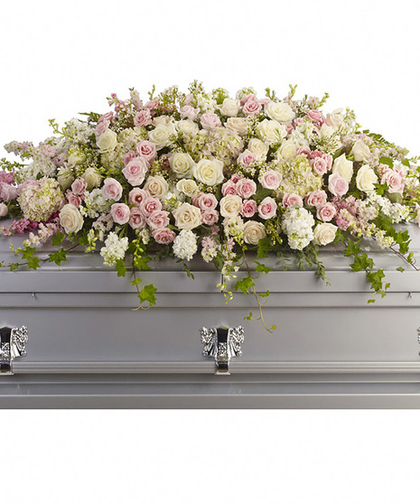 Casket spray of soft pink, white and creme blooms.
