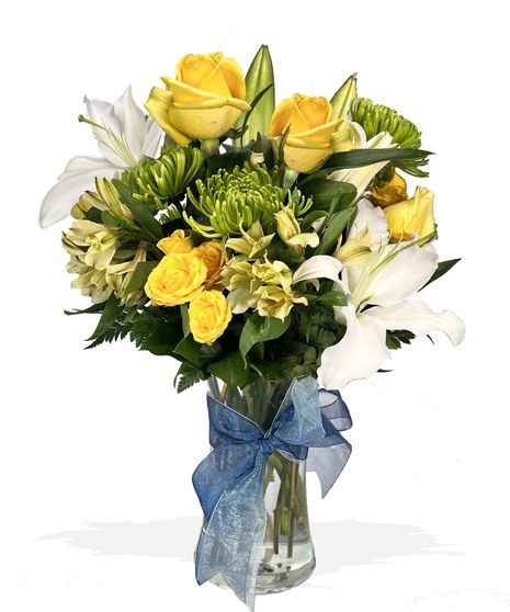 White and yellow flowers in a clear glass vase accented with blue and lavender ribbon.