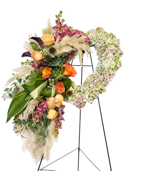 Sympathy wreath of pastel pink, peach and purple flowers