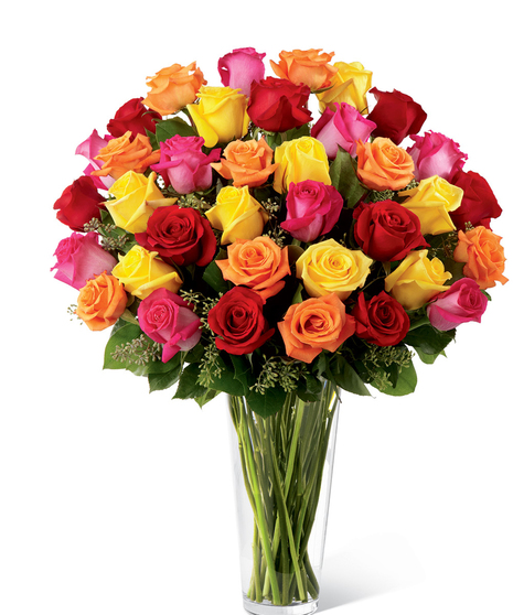 One dozen hot pink, orange and yellow roses with seeded eucalyptus in a clear glass vase. 