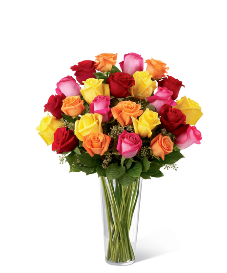 One dozen hot pink, orange and yellow roses with seeded eucalyptus in a clear glass vase. 