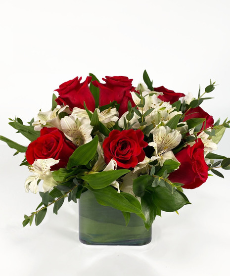 Red roses and white alstroemeria in a contemporary silver cube vase. 