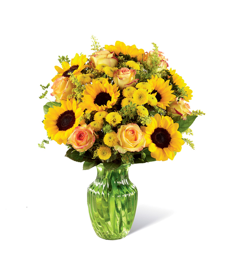 Sunflowers, yellow roses and other yellow flowers in a clear glass vase.