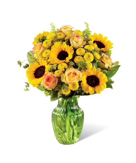 Sunflowers, yellow roses and other yellow flowers in a clear glass vase.