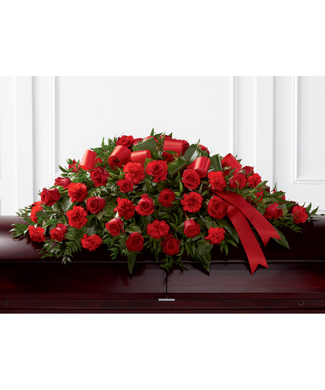 Casket spray of red roses and carnations accented with red ribbon. 