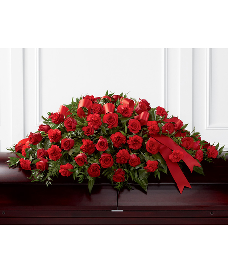 Casket spray of red roses and carnations accented with red ribbon. 