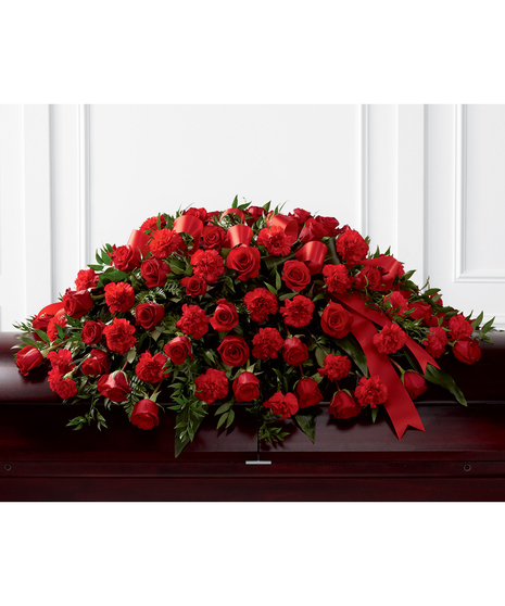 Casket spray of red roses and carnations accented with red ribbon. 