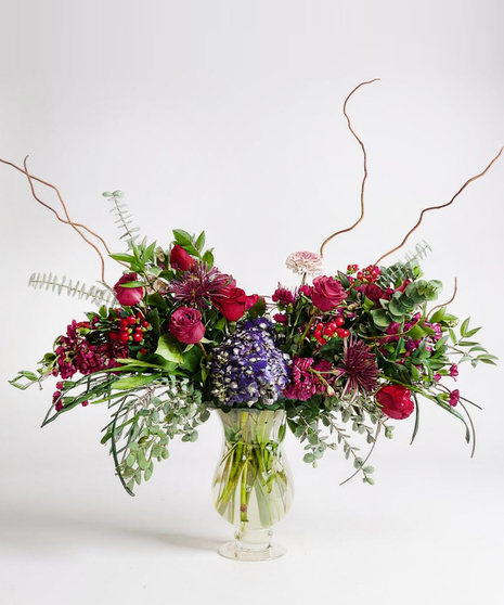 Sympathy wreath of pastel pink, peach and purple flowers with coordinating ribbon. 