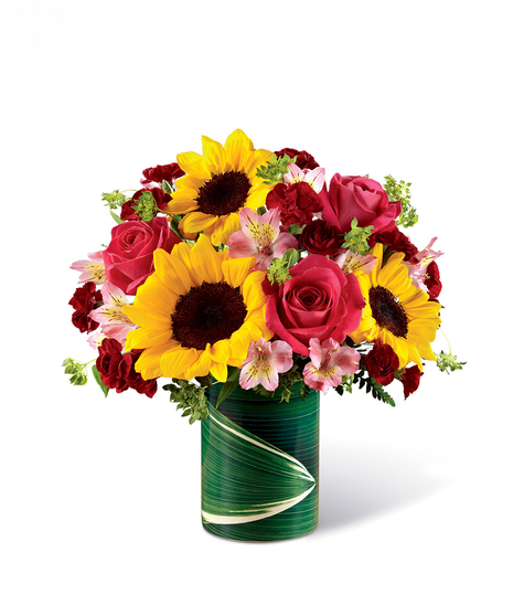 Sunflowers, pink roses and alstroemeria, and mini burgundy carnations in a ceramic illusion vase. 