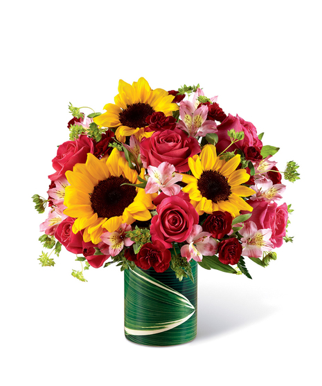 Sunflowers, pink roses and alstroemeria, and mini burgundy carnations in a ceramic illusion vase. 