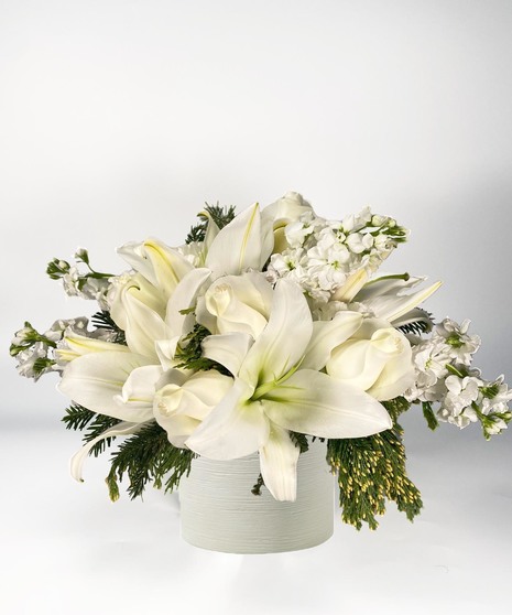Mirrored silver cube of white roses, lilies and more. 