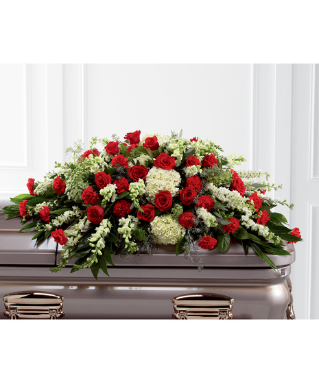 Casket spray of red roses and carnations, white hydrangea, larkspur, snapdragons and more. 