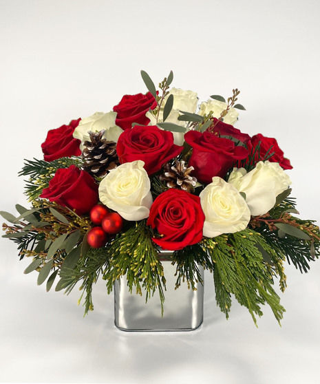 Mirrored cube of red and white roses with greenery.