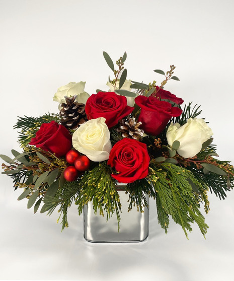 Mirrored cube of red and white roses with greenery.