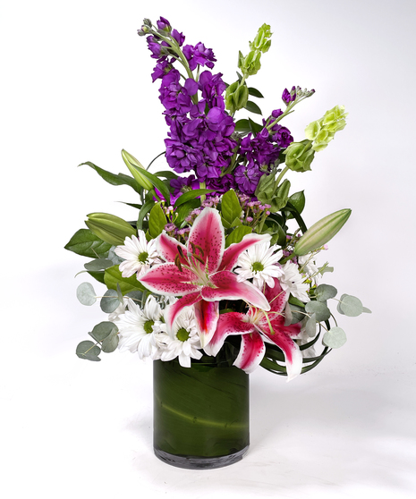 Sunflowers, hydrangea and more in a clear glass vase. 