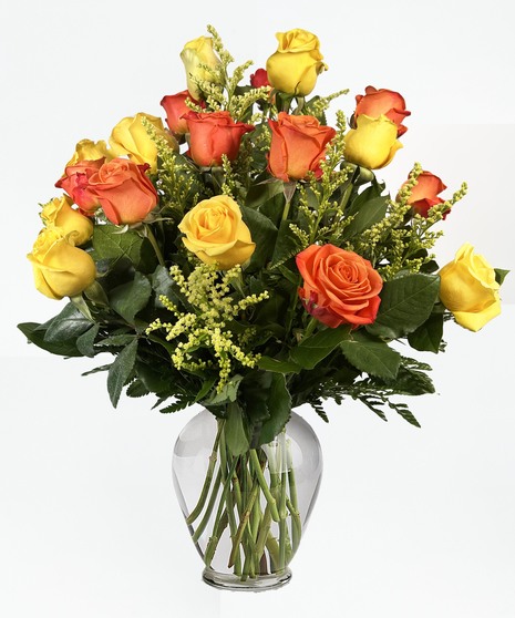 Roses in shades of orange in a clear glass vase.