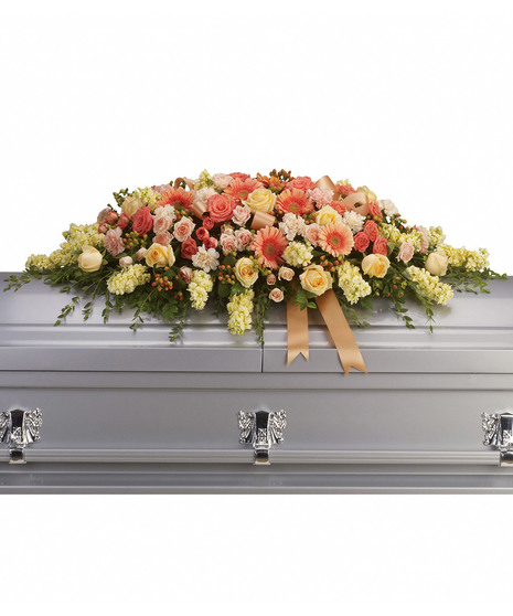 Casket spray of orange and peach flowers with coordinating ribbon. 