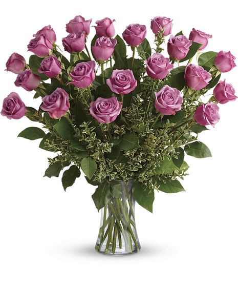 Bouquet of lavender roses with seeded eucalyptus in a clear glass vase. 